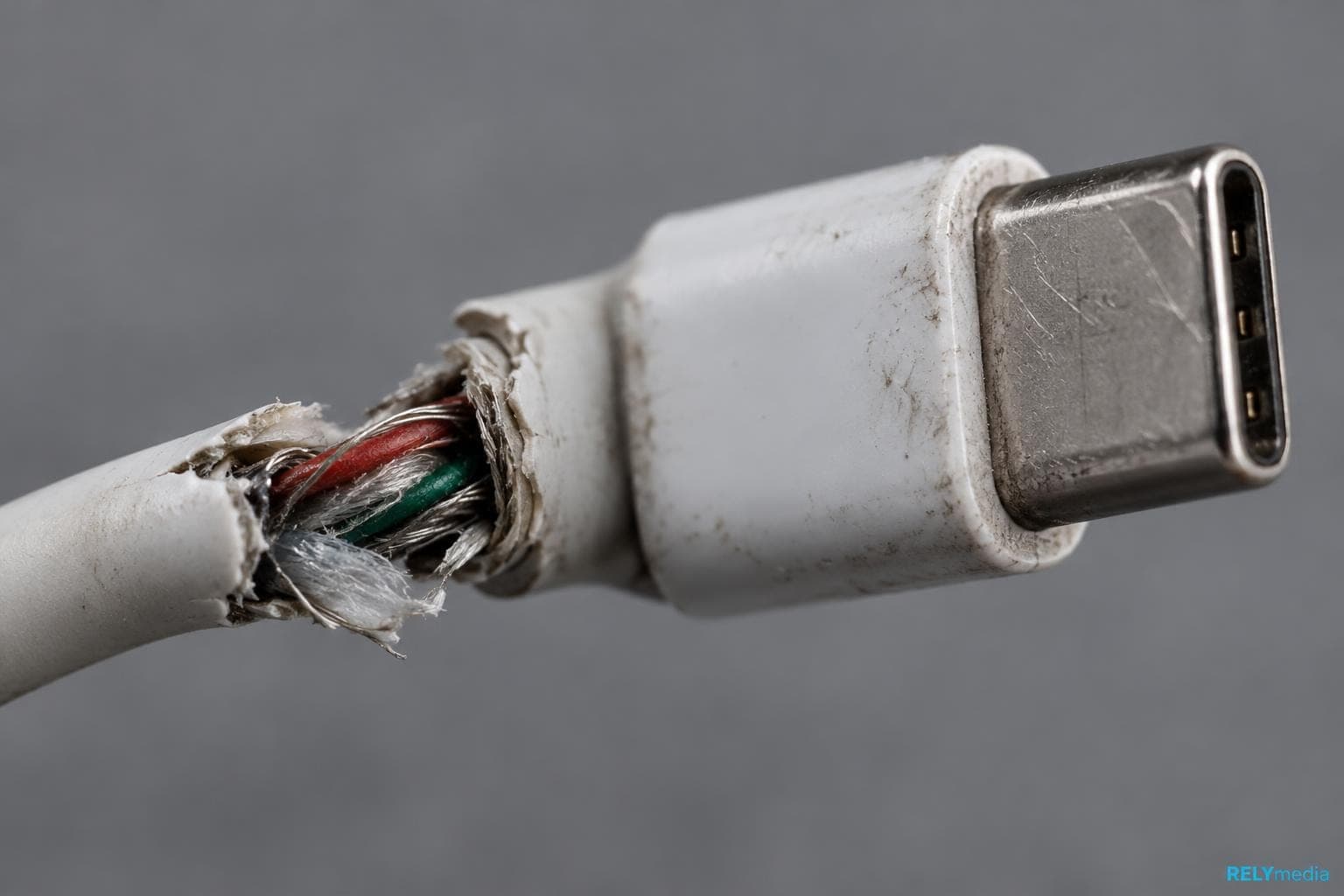 Close-up of a frayed USB charging cable