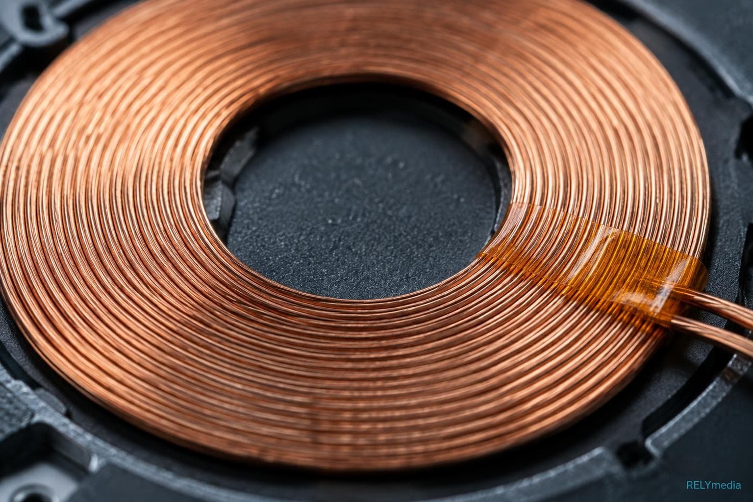 Close-up of a copper charging coil inside a wireless charger